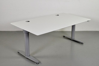 Hæve-/sænkebord fra Kinnarps med hvid demoplade,med kabelhuller, og grå stel